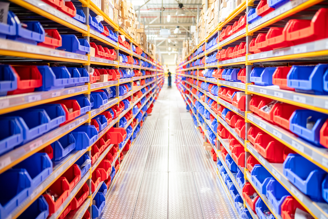 Diminishing perspective of warehouse racks filled with red and blue trays
